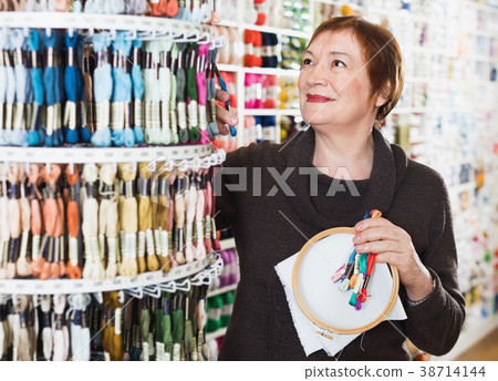 Woman choosing mouline for embroidery in needlework shop Woman choosing mouline for embroidery in needlework shop 38714144