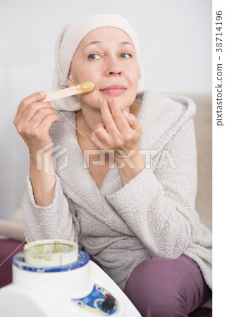 Woman doing body hair removal 38714196