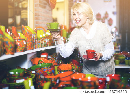 Smiling mature woman customer buying ceramic cup Smiling mature woman customer buying ceramic cup 38714223