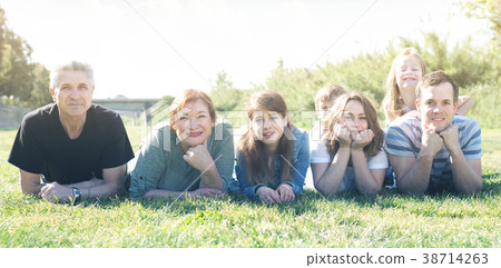 Smiling people taking photos on the lawn Smiling people taking photos on the lawn 38714263