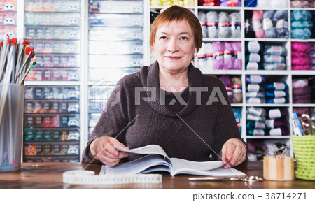Woman sits at desc in shop 38714271