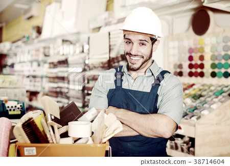 Smiling master standing near basket with tools 38714604