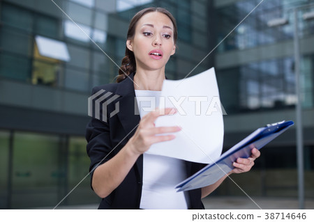 Businesswoman is examining documents Businesswoman is examining documents 38714646