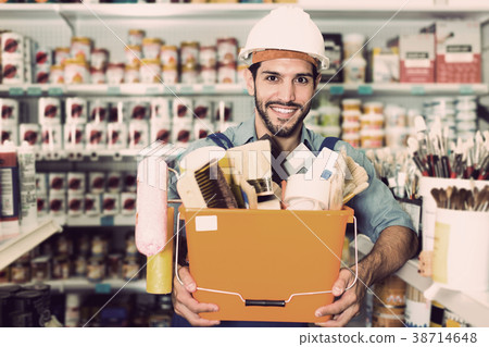 Positive workman holding basket with tools in store Positive workman holding basket with tools in store 38714648