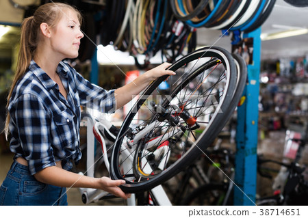 Girl master is replacing wheel of bicycle Girl master is replacing wheel of bicycle 38714651