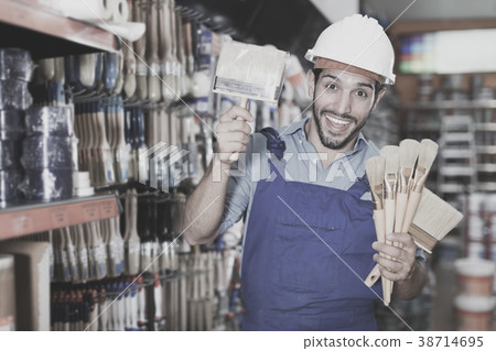 Workman selecting brushes in store 38714695