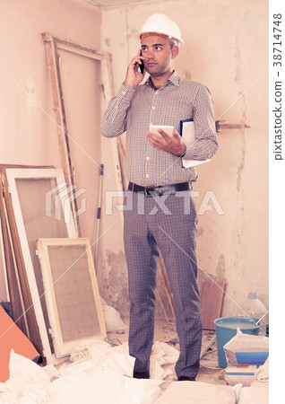 Man engineer talking on the mobile phone Man engineer talking on the mobile phone 38714748