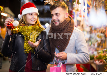 young couple in Christmas hat buying decoration at fair 38715245