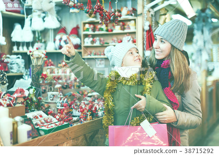 Girl with woman choosing Christmas gifts for family Girl with woman choosing Christmas gifts for family 38715292