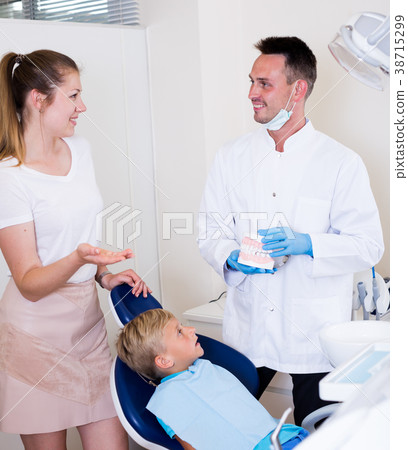 Adult woman is talking with dentist about her child`s health Adult woman is talking with dentist about her child`s health 38715299