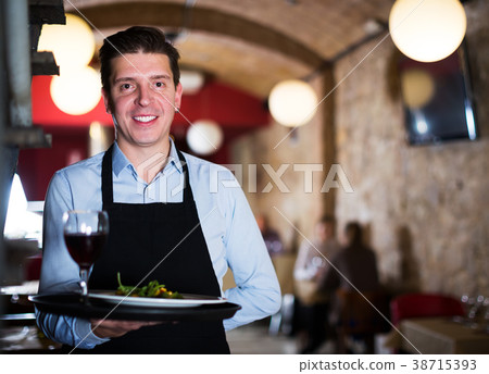 Waiter holding tray at restaurant 38715393