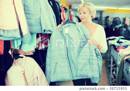 Mature woman buyer choosing windbreaker jacket Mature woman buyer choosing windbreaker jacket 38715953