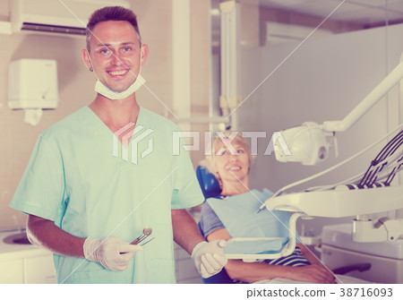 Male dentist standing in dental office Male dentist standing in dental office 38716093