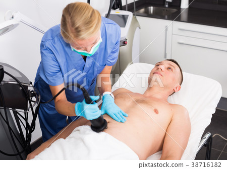 Female specialist is massaging with vacuum to belly of client for anti-fat Female specialist is massaging with vacuum to belly of client for anti-fat 38716182