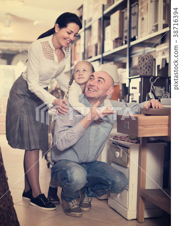 couple with the daughter choosing furniture 38716394