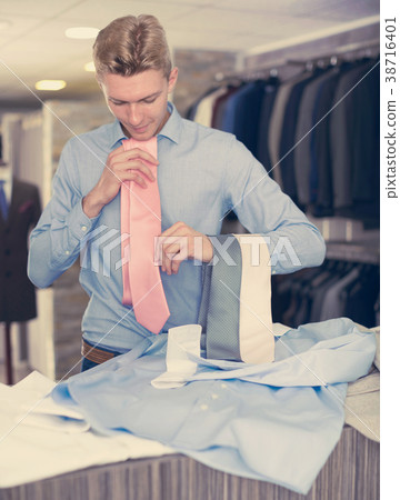 Portrait of man customer choosing tie Portrait of man customer choosing tie 38716401
