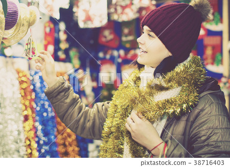 girl choosing Christmas decoration at market girl choosing Christmas decoration at market 38716403