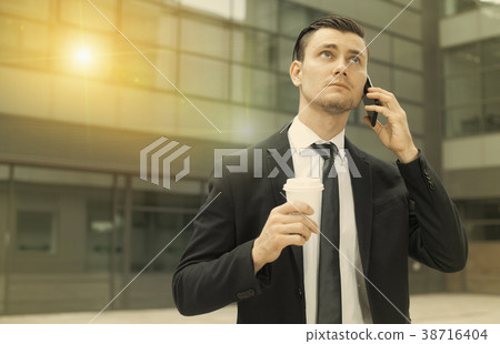 Office manager is drinking coffee and talking phone 38716404