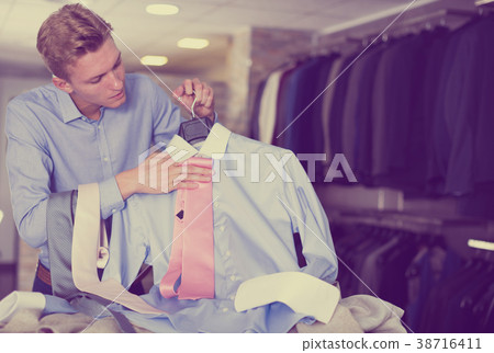 Adult male purchaser choosing tie Adult male purchaser choosing tie 38716411