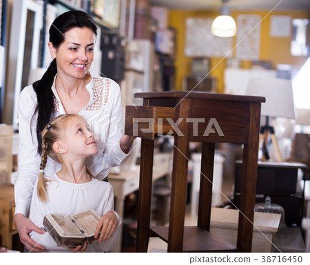 Smiling female with daughter standing with curbston 38716450