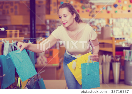 Woman demonstrates multi colored bags Woman demonstrates multi colored bags 38716587