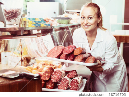 Portrait of young woman having tray with salami Portrait of young woman having tray with salami 38716703