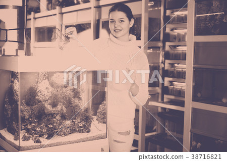Smiling girl is keeping aquarium net and water container next to 38716821