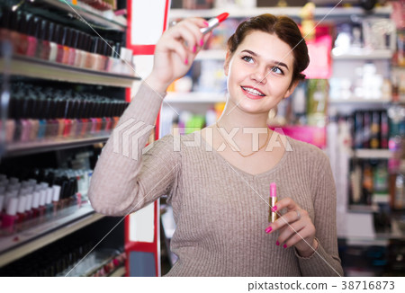 female customer looking for lipstick in cosmetics shop female customer looking for lipstick in cosmetics shop 38716873