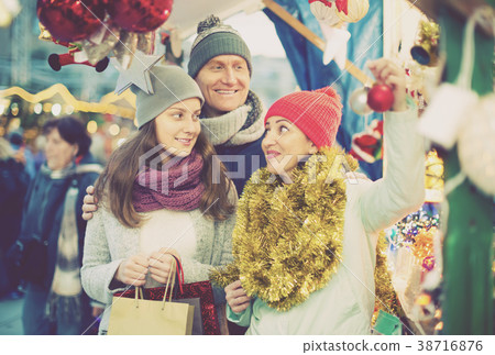 joyous married couple with a teenage daughter at Christmas market joyous married couple with a teenage daughter at Christmas market 38716876