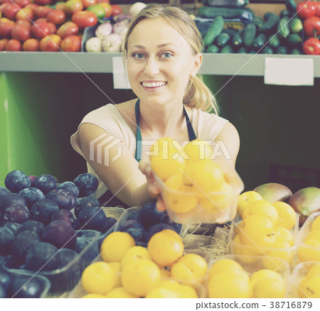 Portrait of happy woman selling ripe fresh plums Portrait of happy woman selling ripe fresh plums 38716879