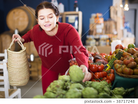 Teenager takes an artichoke 38717248