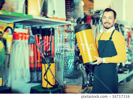 Laughing guy deciding on best garden sprayer Laughing guy deciding on best garden sprayer 38717316