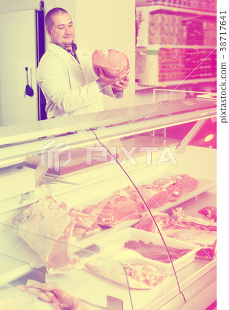 Glad salesman near display with cooled meat Glad salesman near display with cooled meat 38717641