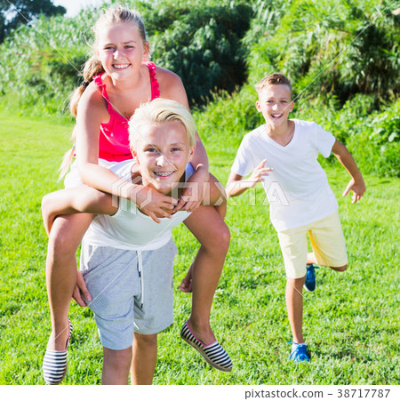 Girl with two friends running on park 38717787