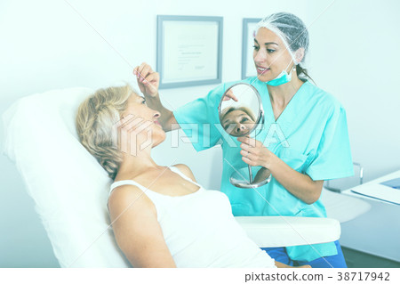 Cosmetologist consulting lady Cosmetologist consulting lady 38717942