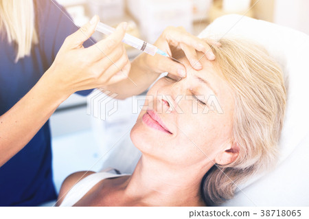Senior woman getting facial injection Senior woman getting facial injection 38718065