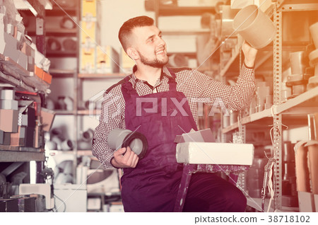 Male worker choosing drain pipe detail Male worker choosing drain pipe detail 38718102