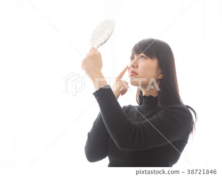 A woman troubled watching a mirror 38721846