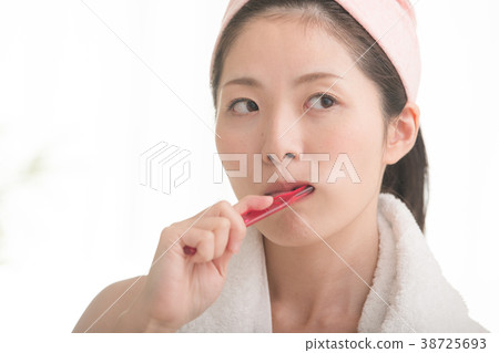 A young woman brushing her teeth 38725693