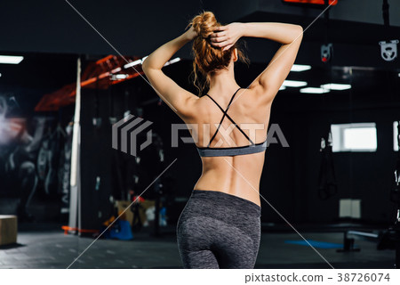 Crossfit woman standing with her back in the gym. 38726074