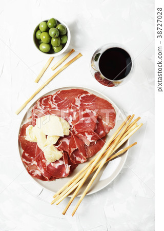 Delicious appetizer with bread sticks and ham 38727028