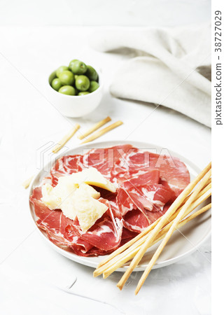 Delicious appetizer with bread sticks and ham 38727029