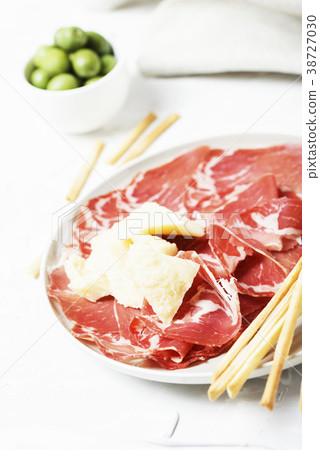 Delicious appetizer with bread sticks and ham Delicious appetizer with bread sticks and ham 38727030