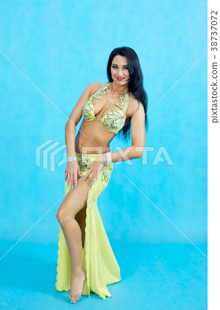 Charming dancer performs oriental belly dance on a blue background. 38737072