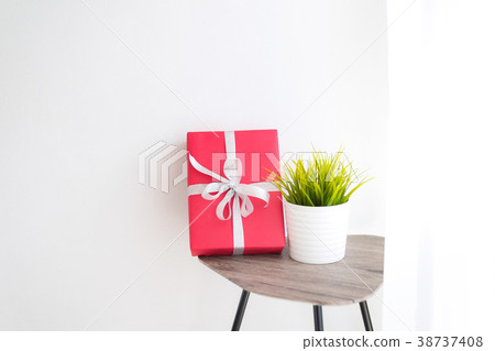 Red Gife Box with A White Pot Green Plant on Table 38737408