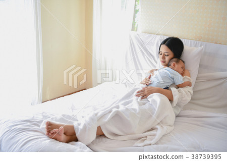 Newborn Concept. Mother and child on a white bed. Mom and baby b 38739395