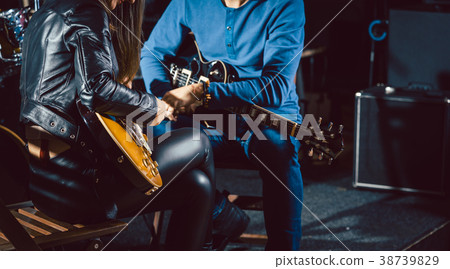 Guitar music teacher helping his student 38739829