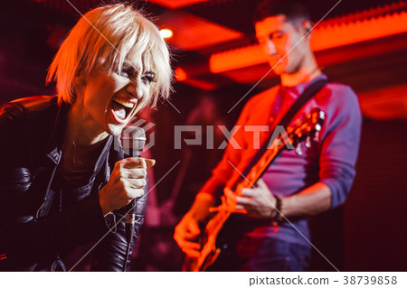 Band during gig making rock music on stage 38739858