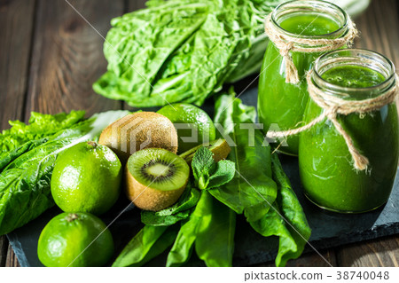 Blended green smoothie with ingredients on the Blended green smoothie with ingredients on the 38740048