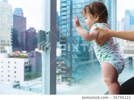Toddler boy looking out at the city a glass Toddler boy looking out at the city a glass 38740122